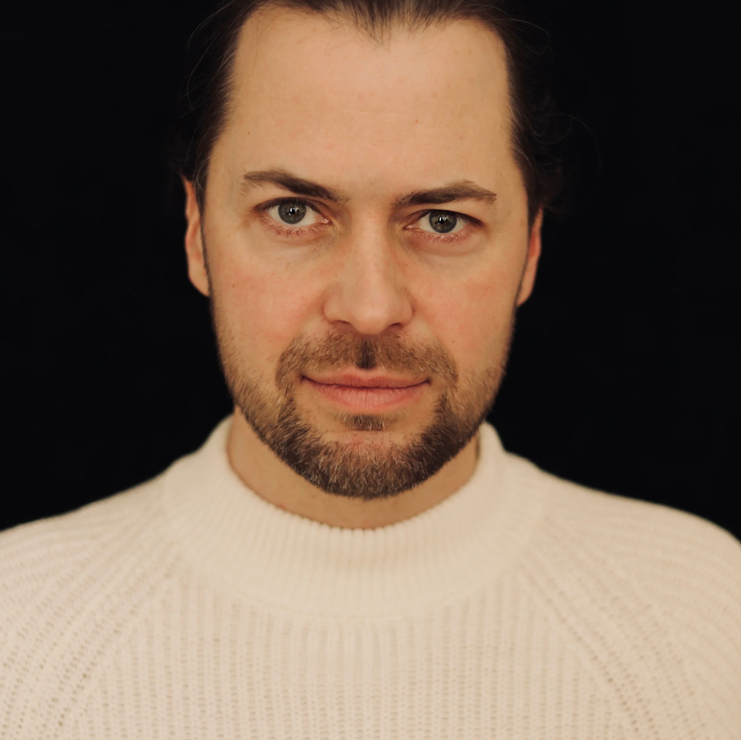 Porträt von Simon Anke im weißen Strickpullover